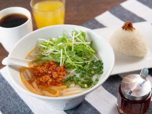 APA Hotel Ueno Hirokoji في طوكيو: وعاء من الحساء على طاولة مع طبق من الأرز
