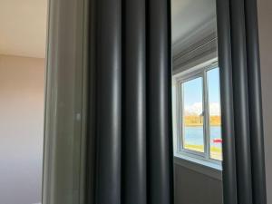 ein Fenster in einem Zimmer mit Blick auf das Wasser in der Unterkunft Bunessan Inn in Bunessan