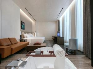 ein Wohnzimmer mit einem Sofa und einem Bett in einem Zimmer in der Unterkunft Zhengzhou The Grand House in Zhengzhou