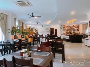 una sala da pranzo con tavoli e sedie e un ristorante di Boulevard Phú Quốc PQ - by BAY LUXURY a Phu Quoc