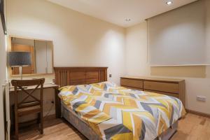 a bedroom with a bed and a desk and a chair at Ocean Village 2 bedroom apartment in Gibraltar