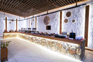 een restaurant met een stenen muur en een bar bij Sama al Wasil Desert Camp in Shāhiq