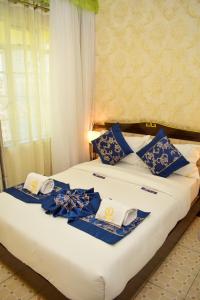 een bed met blauwe en witte kussens erop bij Limpopo Suites in Nairobi
