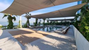 a swimming pool with lounge chairs and an umbrella at 3Bed Private Beach - Belle vie à La Vie Dubai in Dubai