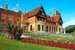 a large brick building with flowers in front of it at 4 Rooms Playa Surf Cine- Parking y Terraza in Donostia-San Sebastián