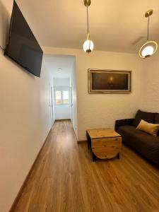 ein Wohnzimmer mit Sofa und Tisch in der Unterkunft MI CASA ES TU CASA in Hospitalet de Llobregat + 13 Fotos