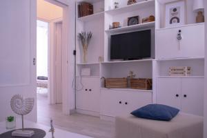 sala de estar con TV en un estante blanco en Cozy apartment in the heart of the historic center, en Corfú
