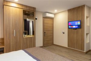 a hotel room with a bed and a tv on a wall at Ema Houses in Antalya