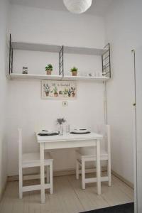 una mesa blanca y sillas en una habitación en Cozy apartment in the heart of the historic center, en Corfú