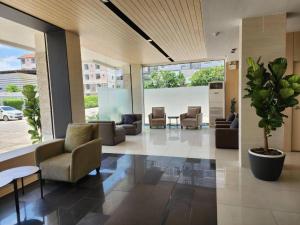 um átrio de escritório com cadeiras e um vaso de plantas em Lee Nova Hotel em Bangna