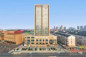 een uitzicht op een hoog gebouw in een stad bij Xana Hotelle Tianjin Jingang Road Huaxi Branch in Jinnanqu