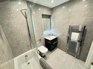 y baño con aseo, lavabo y ducha. en Stunning Beach Front Apartment with Sea views, FREE Parking & Balcony en Ramsgate