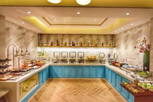 a large kitchen with blue cabinets and marble walls at Magnotel Hotel Chengdu Taikoo Li Dongfeng Bridge A in Chengdu