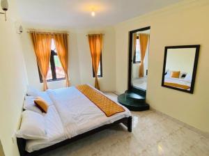 a bedroom with a large bed and a mirror at BOB Lesiure in Ooty