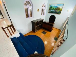 uma sala de estar com um sofá azul e uma secretária em BOB Lesiure em Ooty