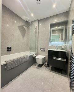 La salle de bains est pourvue d'un lavabo, de toilettes et d'une baignoire. dans l'établissement Stunning Beach Front Apartment with Sea views, FREE Parking & Balcony, à Ramsgate