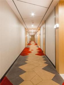 un pasillo de un edificio de oficinas con alfombra roja en Borrman Hotel Kunming Dianchi South Asia Fengqingyuan en Kunming