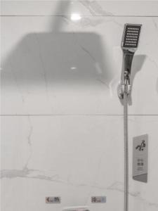 un bagno con soffione doccia e soffitto bianco di Borrman Hotel Kunming Dianchi South Asia Fengqingyuan a Kunming