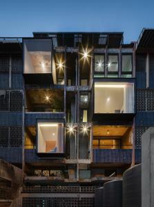 an external view of a building with lights on at Stupid Stay in Bangkok
