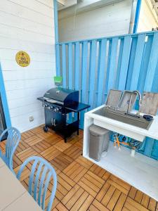 a grill on a deck with a table and chairs at Sawa Terrace - Vacation STAY 97941v in Amami
