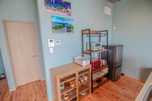cocina con nevera y estante con microondas en Sawa Terrace - Vacation STAY 97941v en Amami