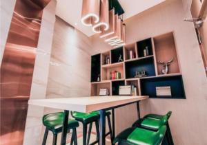 un bar con taburetes verdes en una habitación en City Comfort Inn Changchun Chongqing Road Huolicheng, en Changchún