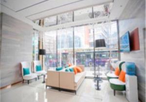 una sala de estar con sofás y sillas y una gran ventana en City Comfort Inn Changchun Chongqing Road Huolicheng, en Changchún