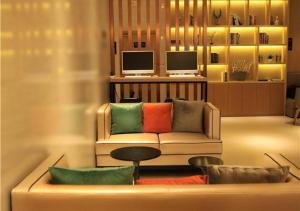a living room with a couch with colorful pillows at City Comfort Inn Hefei Wulimiao Feihe Road in Hefei