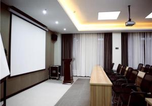 a conference room with a large screen and chairs at City Comfort Inn Hefei Wulimiao Feihe Road in Hefei