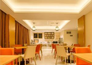 a dining room with tables and chairs and a kitchen at City Comfort Inn Haikou Zhongjie Road Walking Street in Haikou