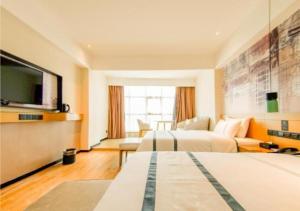 a hotel room with two beds and a flat screen tv at City Comfort Inn Haikou Zhongjie Road Walking Street in Haikou