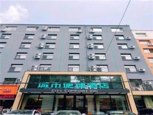 un gran edificio con un cartel delante en City Comfort Inn Changchun Wenhua Square Xi Zhonghua Road en Changchún