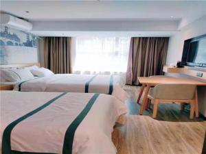 Habitación de hotel con 2 camas, escritorio y TV. en City Comfort Inn Changchun Wenhua Square Xi Zhonghua Road, en Changchún