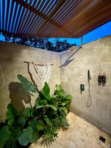 a bathroom with a shower and a plant at Black Wood Cabin in Kintamani