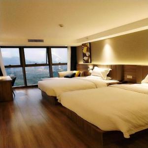 Habitación de hotel con 2 camas y ventana grande. en 7 Days Premium Hotel Chongqing Jiangbei International Airport Terminal 3 en Shiping