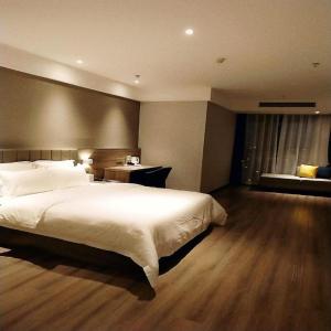 1 dormitorio con 1 cama blanca grande y escritorio en 7 Days Premium Hotel Chongqing Jiangbei International Airport Terminal 3 en Shiping