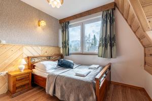Schlafzimmer mit einem Bett und einem Fenster in der Unterkunft Apartamenty pod Słońcem in Kościelisko