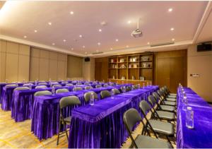 Habitación grande con mesas y sillas de color púrpura. en Echarm Hotel Jiaxing Xiuhu Park Government Center en Jiaxing