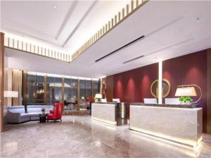 a lobby of a hotel with a red wall at E-Cheng Hotel Changchun Yiqi West High-Speed Railway Station in Changchun