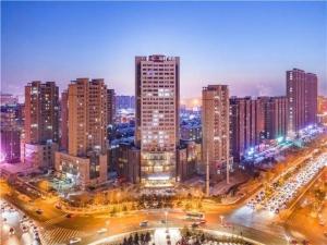 un perfil urbano con edificios altos y tráfico por la noche en E-Cheng Hotel Changchun Yiqi West High-Speed Railway Station, en Changchún