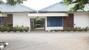 ein weißes Gebäude mit einer Tür und einem Innenhof in der Unterkunft Hotel New Puri Garden in Kalibanteng-lor