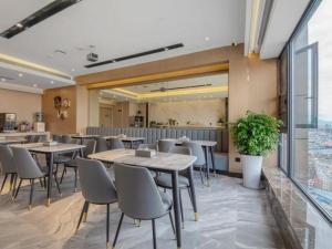 un restaurante con mesas y sillas en una cafetería en Gya Hotel Kunming Zijin Center Xiaodongcun Metro Station, en Kunming