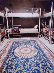 einen Teppich auf dem Boden eines Zimmers mit Etagenbetten in der Unterkunft Neena S Hostel in Ban Nua