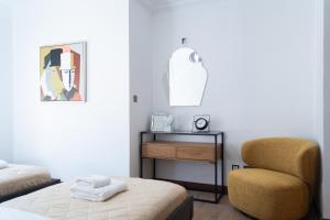 1 dormitorio con cama, silla y espejo en Luxury Pool View Flat L12, en Kouklia