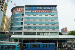 a building with a blue bus in front of it at Hanting Hotel Shenzhen Longgang Nanlian Metro Station in Longgang