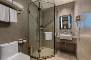 a bathroom with a shower and a toilet and a sink at Hanting Hotel Guangzhou North Railway Station in Huadu