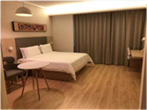 سرير أو أسرّة في غرفة في Hanting Hotel Zhuhai Hengqin International Convention and Exhibition Center