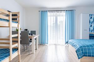 a bedroom with a bed and a desk with a computer at Sosnowe Zacisze - Pokoje Gościnne Blisko Jeziora in Swornegacie