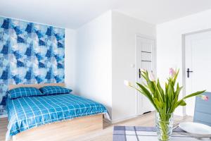 a bedroom with a bed and a blue and white wall at Sosnowe Zacisze - Nowoczesne Pokoje Blisko Jeziora in Swornegacie 