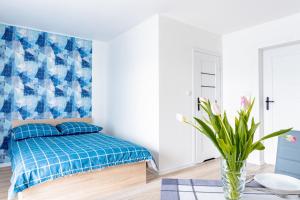 a bedroom with a bed and a blue and white wall at Sosnowe Zacisze - Pokoje Gościnne Blisko Jeziora in Swornegacie